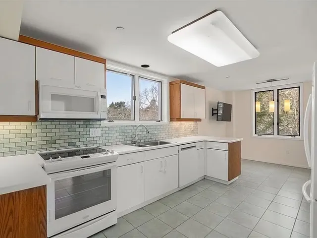a kitchen with granite countertop white cabinets and white appliances