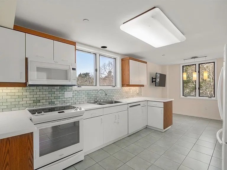 241 Perkins Street, Unit D605 Boston, MA 02130 - Photo 8 of 10 a kitchen with granite countertop white cabinets and white appliances