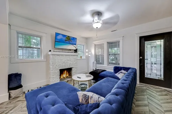 a living room with furniture a fireplace and a window