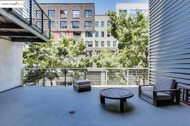 a roof deck with table and chairs and potted plants