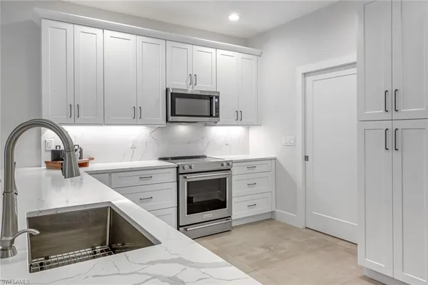 a kitchen with granite countertop a stove top oven microwave and cabinets