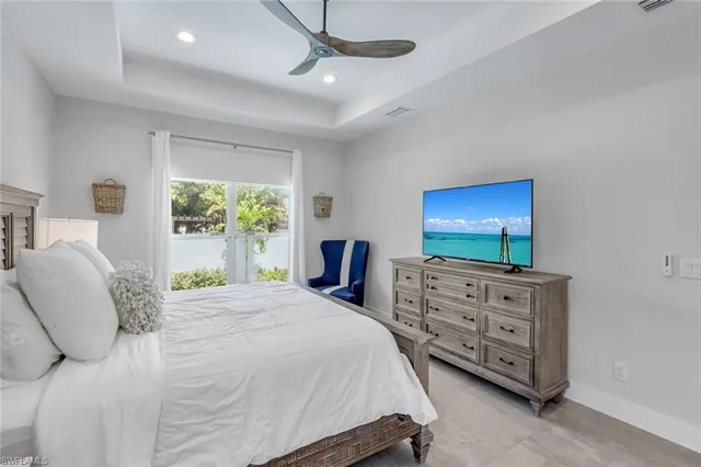 a bedroom with a bed and a flat tv screen on dresser