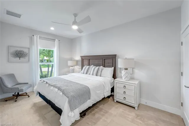 a large bed sitting in a bedroom next to a window