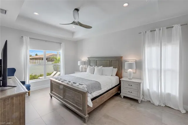 a bedroom with a bed and large windows