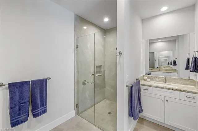 a bathroom with a granite countertop sink a mirror and a shower