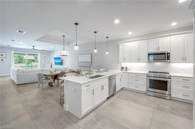 a large white kitchen with a stove and a sink