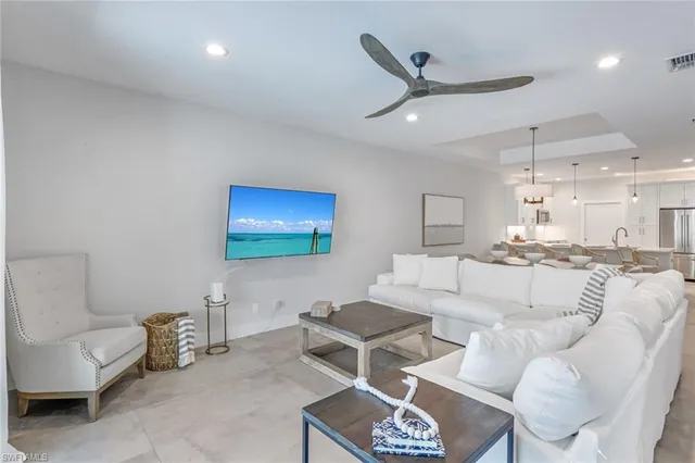 a living room with furniture a ceiling fan and a rug