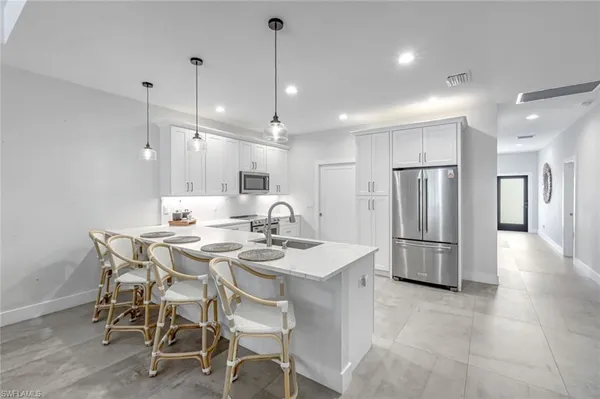 a kitchen with refrigerator and chairs