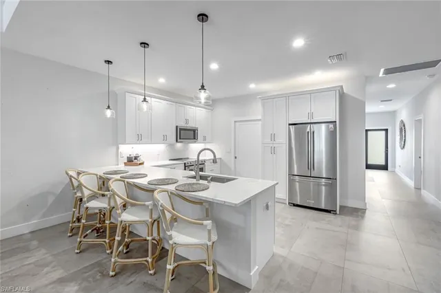 a kitchen with refrigerator and chairs