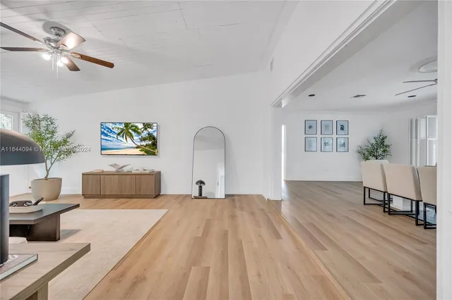 a dining room with stainless steel appliances kitchen island granite countertop a dining table chairs and a living room view