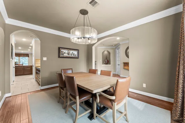 a view of a dining room with furniture a chandelier and wooden floor