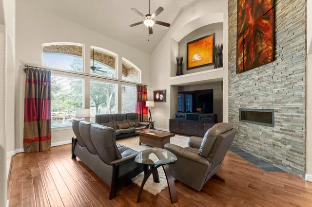 a living room with furniture a fireplace and a floor to ceiling window