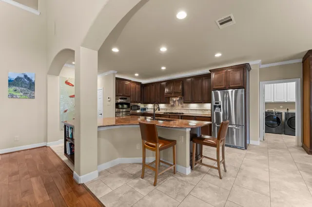 a kitchen with stainless steel appliances granite countertop a refrigerator and a sink