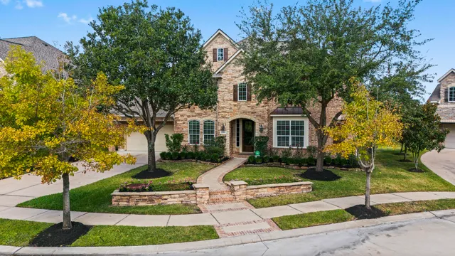 a view of house with outdoor space garden and tall tree