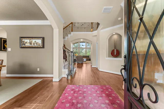 a view of a hallway with wooden floor and furniture
