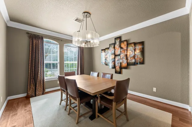a view of a dining room with furniture a chandelier and wooden floor