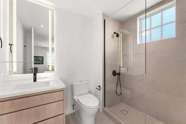 a bathroom with a granite countertop sink a toilet and shower