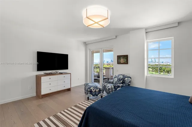 a bedroom with furniture and a flat screen tv