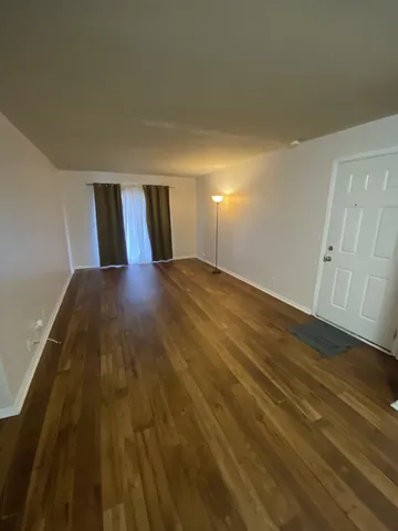 a view of an empty room and wooden floor