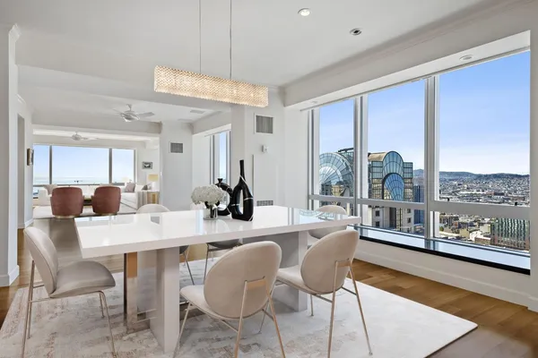 a dining room with furniture a large window and a chandelier