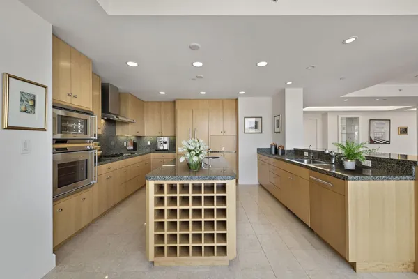a kitchen with stainless steel appliances kitchen island granite countertop a sink and cabinets