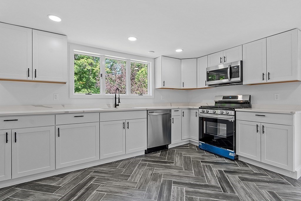 197 Beaman Road Sterling, MA 01564 - Photo 5 of 39 a kitchen with white cabinets and appliances