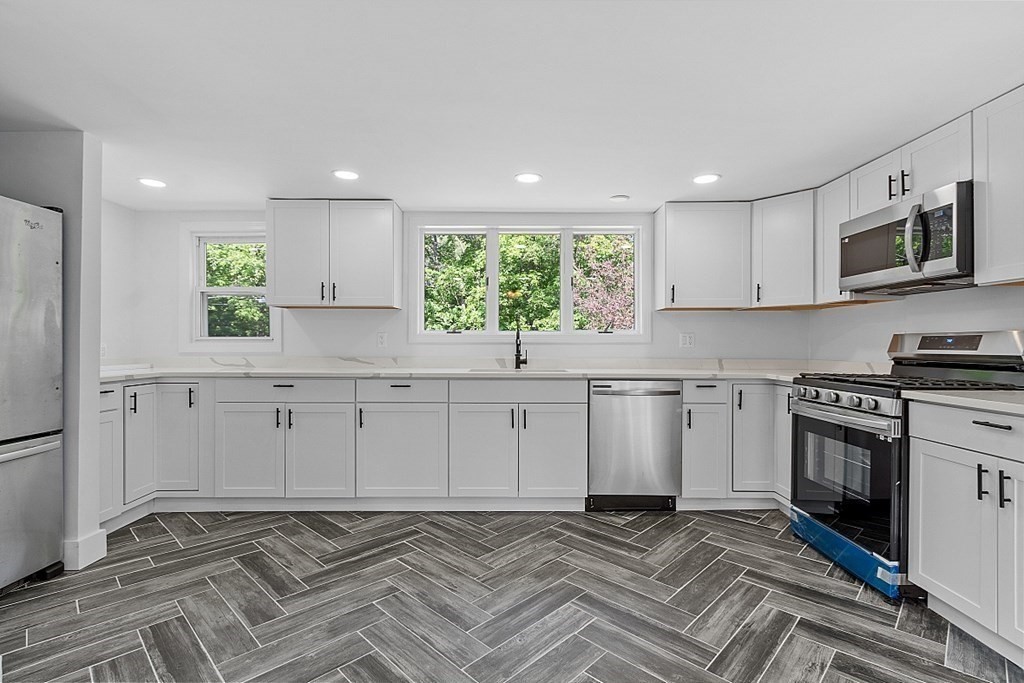197 Beaman Road Sterling, MA 01564 - Photo 6 of 39 a kitchen with white cabinets stainless steel appliances and a window