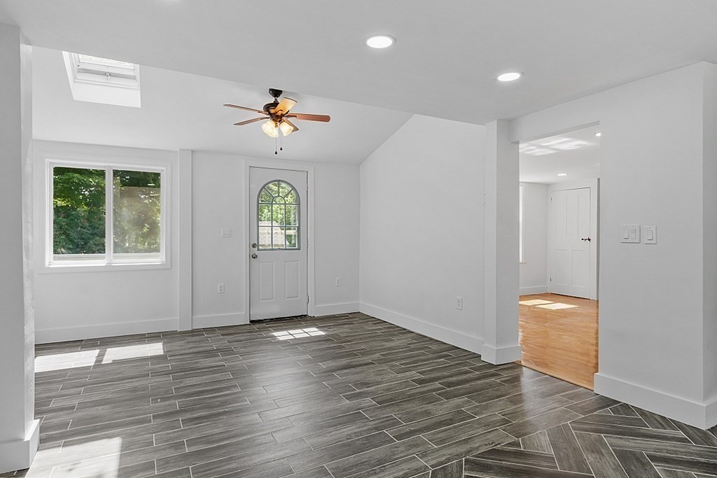 197 Beaman Road Sterling, MA 01564 - Photo 9 of 39 an empty room with wooden floor chandelier fan and windows