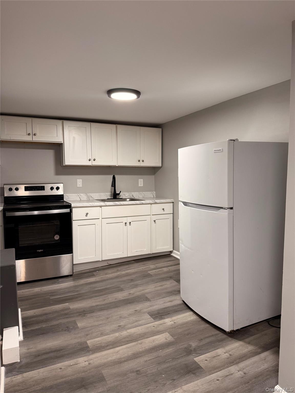 7 Grant Street, Unit 2 Poughkeepsie, NY 12601 - Photo 4 of 13 a kitchen with wooden cabinets and white appliances
