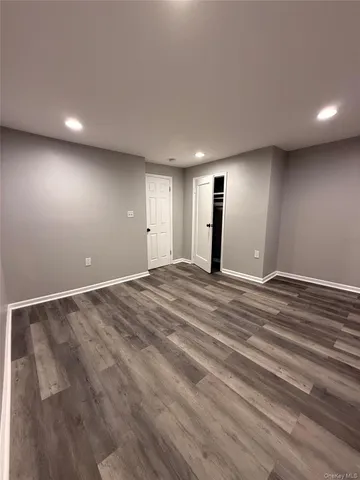 an empty room with wooden floor and window