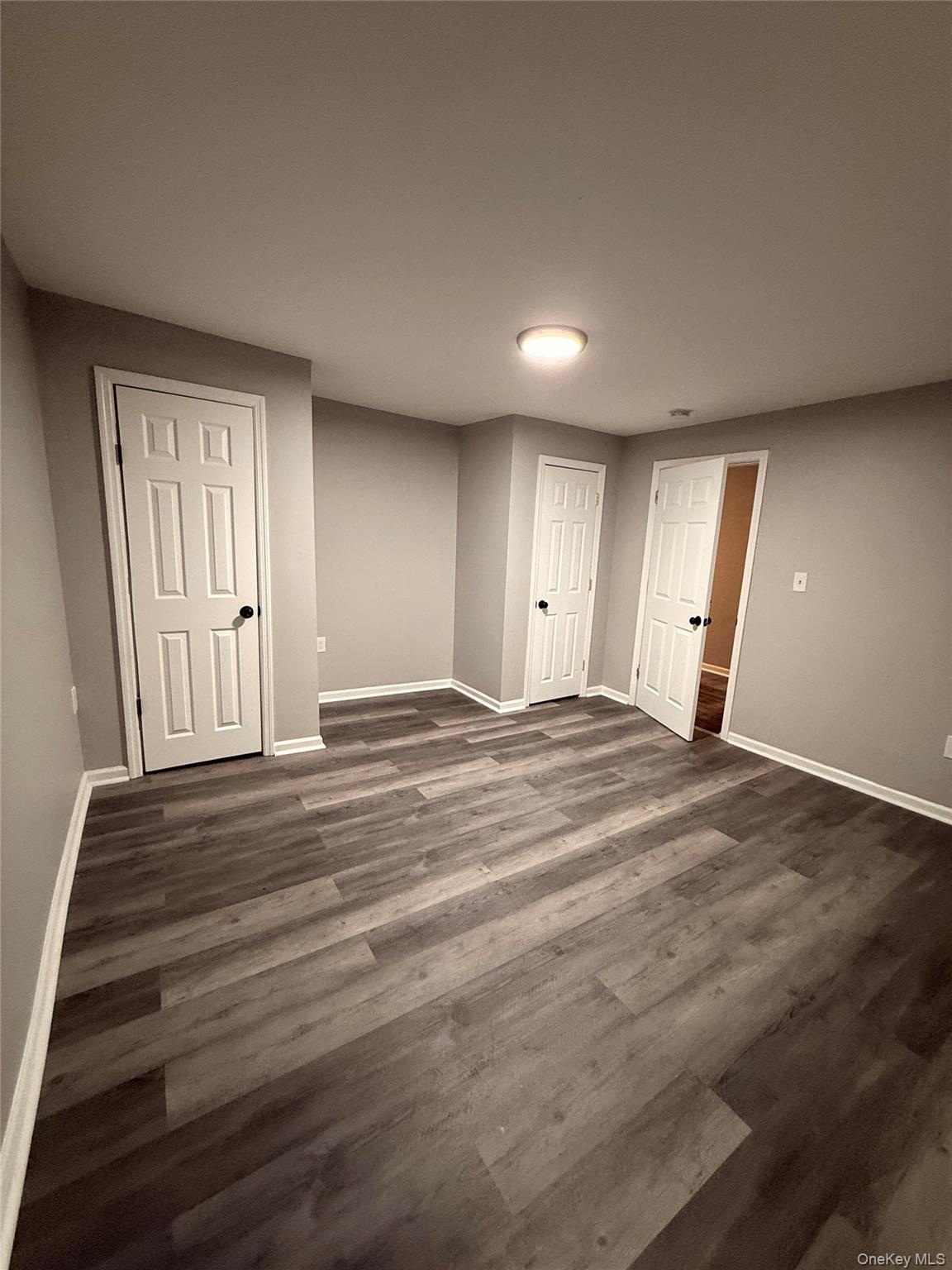 7 Grant Street, Unit 2 Poughkeepsie, NY 12601 - Photo 9 of 13 an empty room with wooden floor and windows
