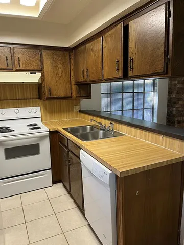 a kitchen with a sink stove and cabinets