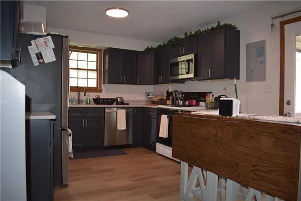 a kitchen with a sink a refrigerator and cabinets