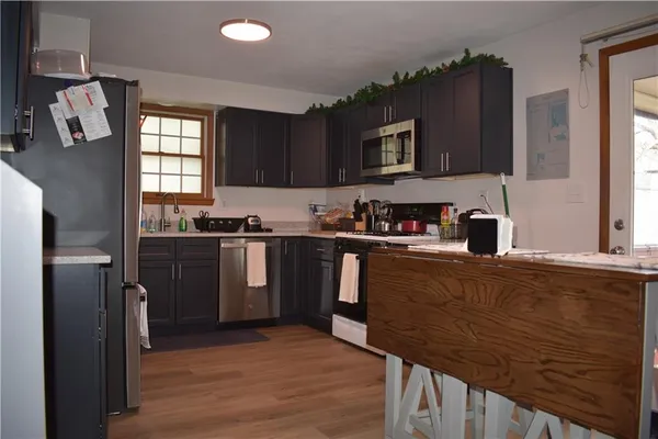 a kitchen with granite countertop a refrigerator stove top oven and sink