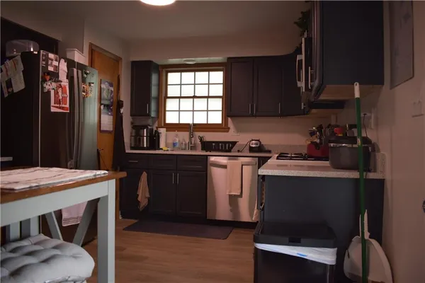 a kitchen with granite countertop a sink appliances a counter space and a window