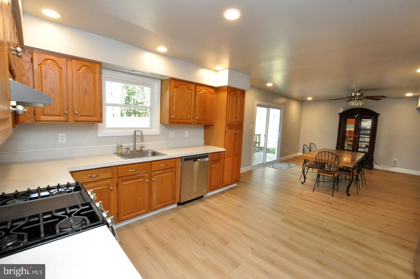 45 Sherri Way Pine Hill, NJ 08021 - Photo 9 of 31 a kitchen with stainless steel appliances granite countertop a stove top oven a sink a dining table and chairs with wooden floor