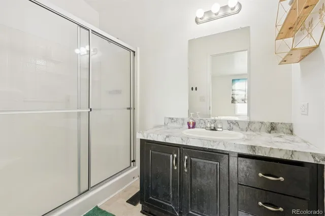 a bathroom with a granite countertop sink and a mirror