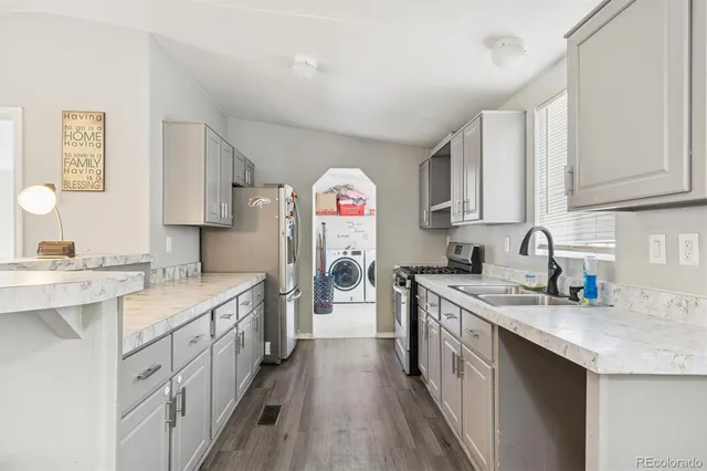 a kitchen with a sink stove cabinets and refrigerator