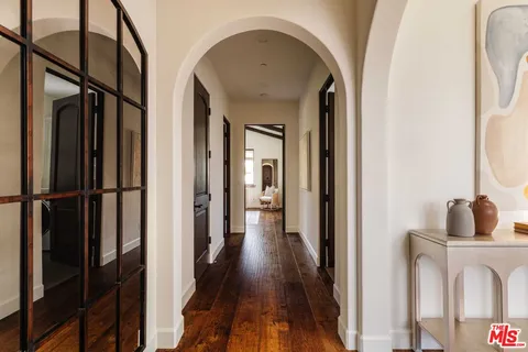 a view of a hallway with wooden floor and staircase