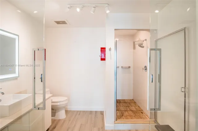 a bathroom with a shower toilet and sink