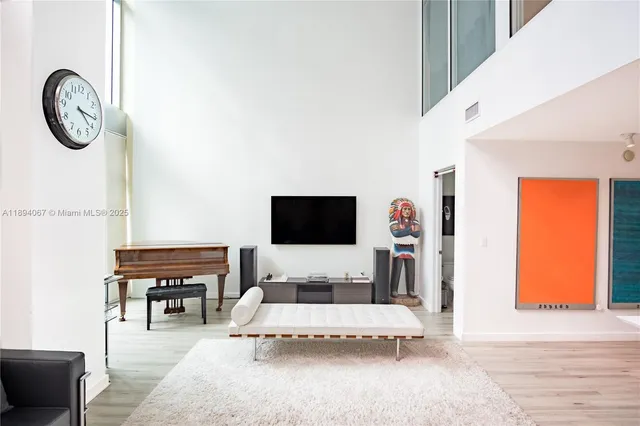 a living room with furniture a flat screen tv and a wall painting