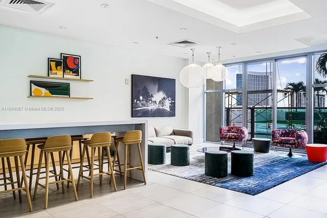 a living room with lots of furniture and a view of kitchen