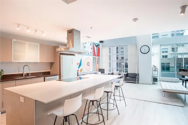 a kitchen with stainless steel appliances a table and chairs in it