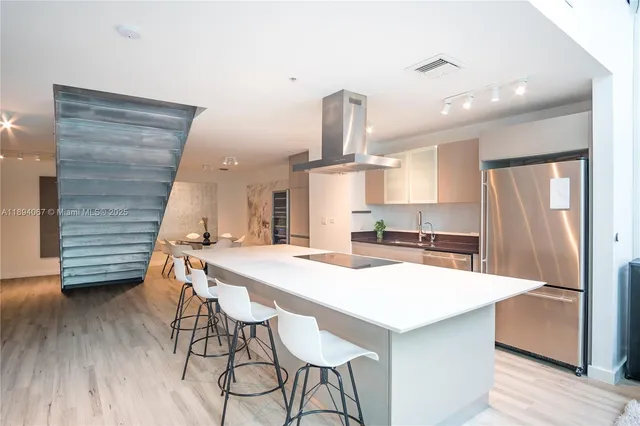 a kitchen with a table chairs refrigerator and cabinets