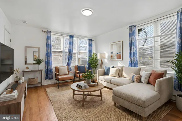 a living room with furniture wooden floor and a large window