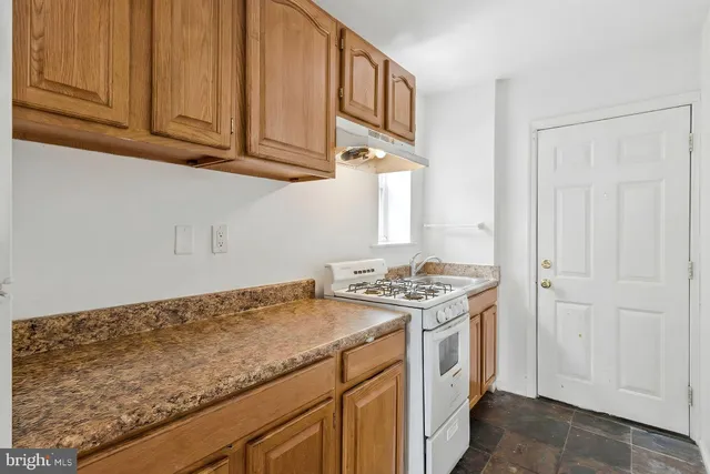 a kitchen with granite countertop a stove and a sink