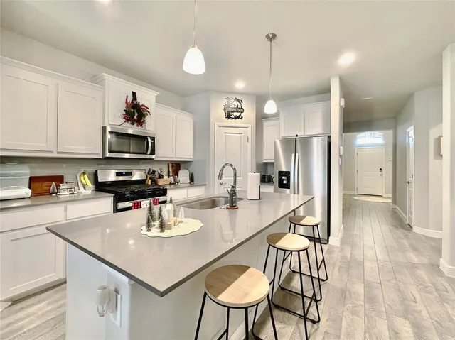 a kitchen with stainless steel appliances granite countertop a stove refrigerator and cabinets