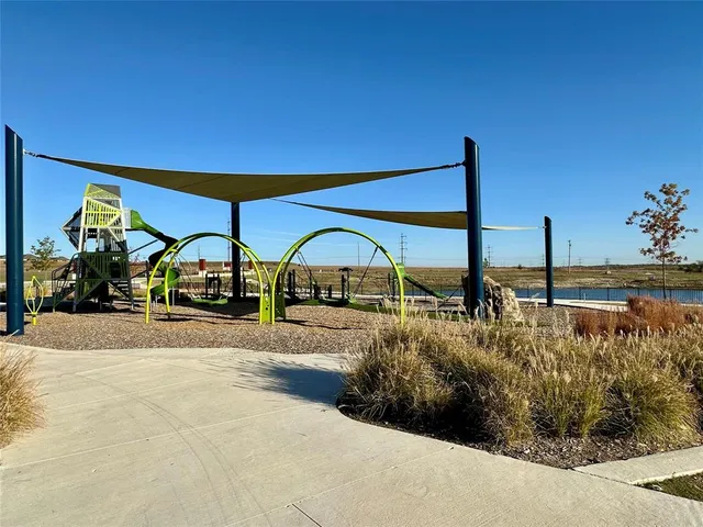 a view of swimming pool with lawn chairs and plants