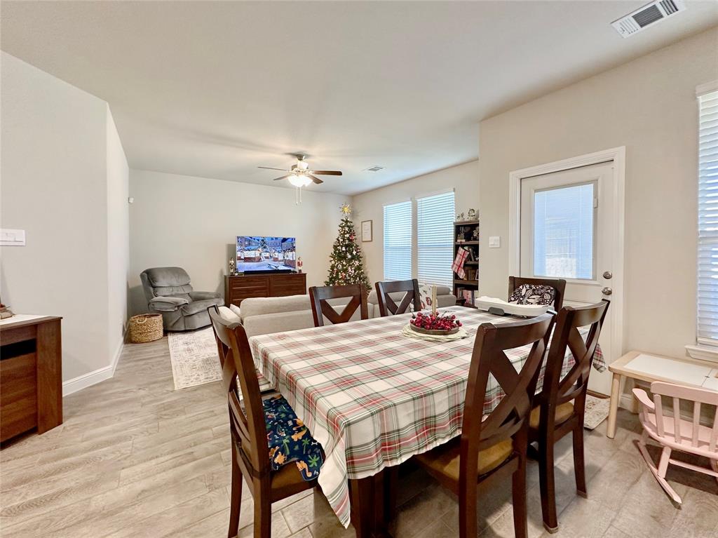 149 Attwater Road Rhome, TX 76078 - Photo 4 of 28 a view of a dining room and livingroom with furniture wooden floor a rug a painting and a chandelier