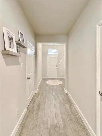 a view of a room with wooden floor and a hallway